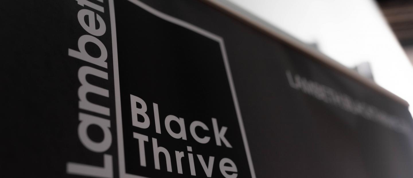 Photo of Lambeth Black Thrive branding material with black background and white text