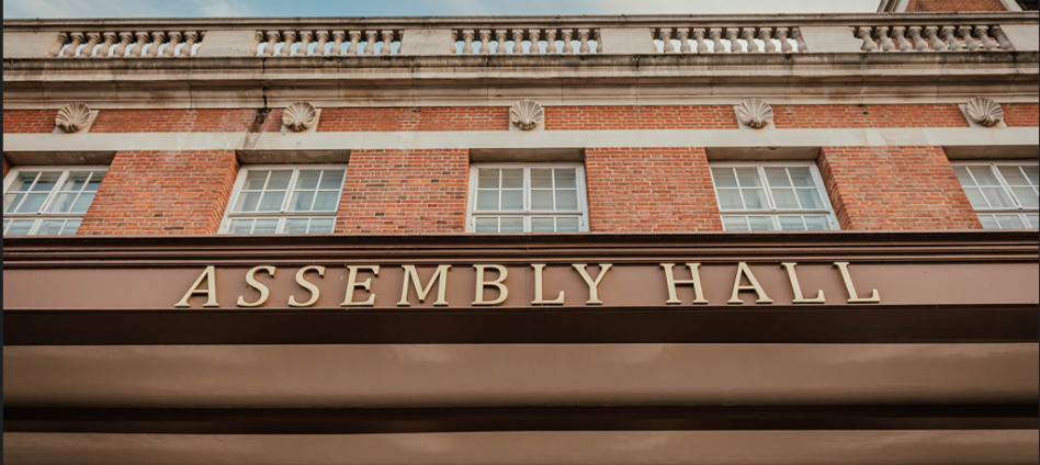 External venue image of gold art-deco text saying Assembly Hall