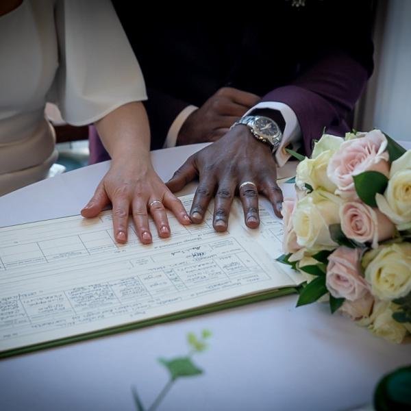 Couple laying hands on their marriage certificate during their ceremony