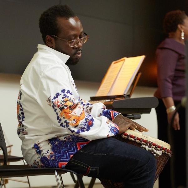 man playing drums in front of sheet music