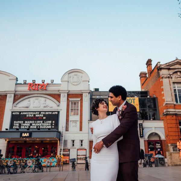 couple smiling against backdrop of Ritzy Cinema